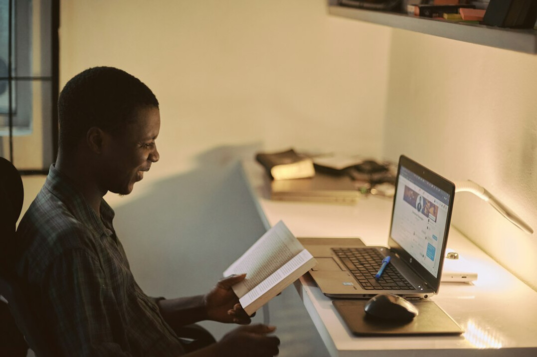 person reading book in office